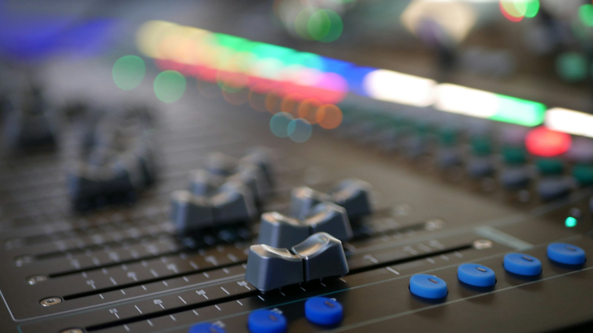 Console de mixagem com faders e luzes coloridas